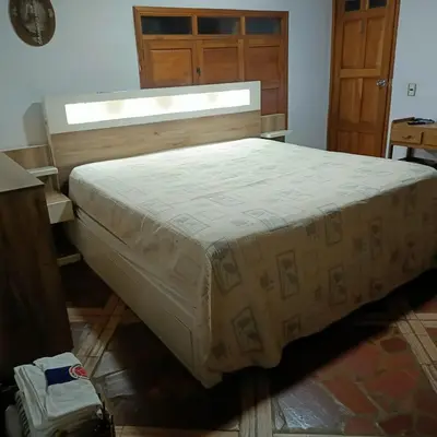 a large bed in a bedroom with a wooden door at Finca 5 Continentes - Cerca MatroCable ARVI in Guarne