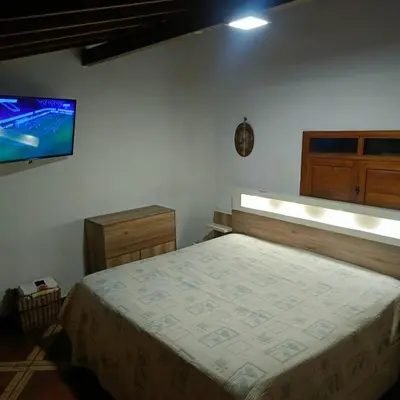 a bedroom with a bed and a flat screen tv at Finca 5 Continentes - Cerca MatroCable ARVI in Guarne