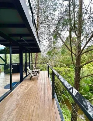 a wooden deck with a bench and a tree at Finca 5 Continentes - Cerca MatroCable ARVI in Guarne