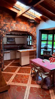 a kitchen with a table and a brick wall at Finca 5 Continentes - Cerca MatroCable ARVI in Guarne