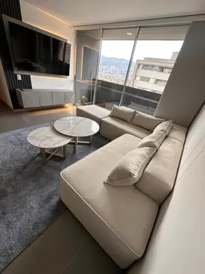 a living room with a couch and a large window at Lujoso apartamento, 3 habitaciones, mejor ubicación in Medellín
