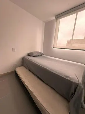 a bed sitting in a room with a window at Apartamento en Medellín poblado in Medellín