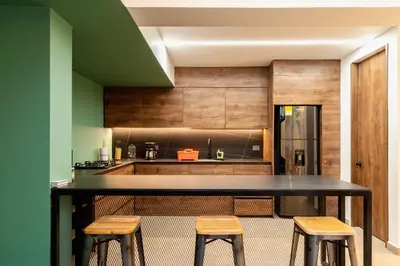 a kitchen with a black counter and stools at Ll 203 4BR 4Bath Apartment close to lleras park - Poblado - Medellín in Medellín