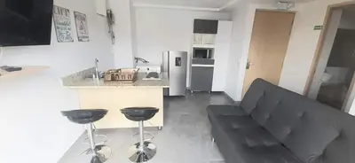 a kitchen with a couch and two bar stools at Cold AC-fast Wi-Fi-great location-Medellin fun in Medellín