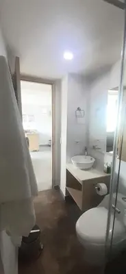 a bathroom with a white toilet and a sink at Cold AC-fast Wi-Fi-great location-Medellin fun in Medellín
