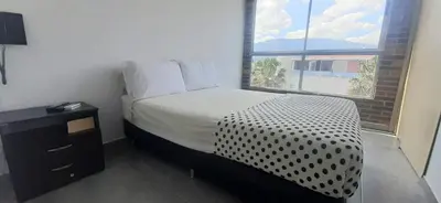 a small bedroom with a bed and a window at Cold AC-fast Wi-Fi-great location-Medellin fun in Medellín