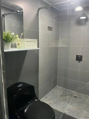 a bathroom with a black toilet and a glass shower at Apartamento en Itagüí in Itagüí