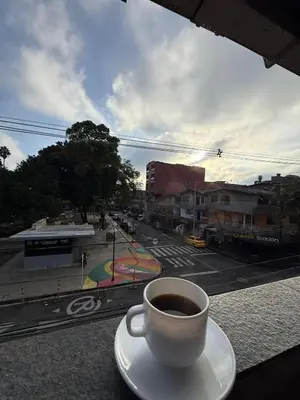 a cup of coffee sitting on a table with a view of a street at Apartamento en Itagüí in Itagüí