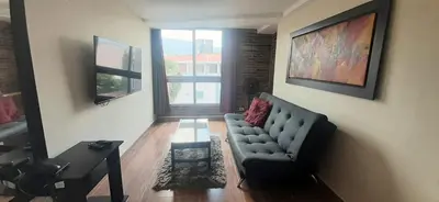 a living room with a couch and a table at New comfortable Laureles Apartment Great location! in Medellín