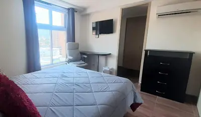 a bedroom with a bed and a dresser and a window at New comfortable Laureles Apartment Great location! in Medellín