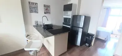 a kitchen with a black refrigerator and a sink at New comfortable Laureles Apartment Great location! in Medellín