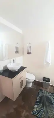 a white bathroom with a sink and a toilet at New comfortable Laureles Apartment Great location! in Medellín