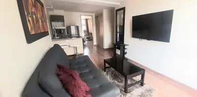 a living room with a couch and a flat screen tv at New comfortable Laureles Apartment Great location! in Medellín