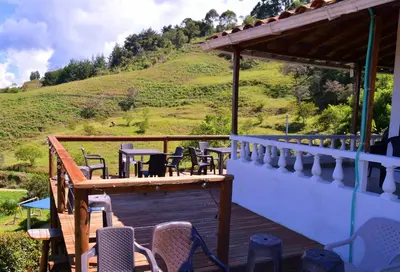 a deck with chairs and tables and a hill at Hermosa Finca Con Piscina y Jacuzzi in El Peñol