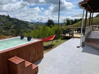 a hot tub with a hammock on a patio at Hermosa Finca Con Piscina y Jacuzzi in El Peñol