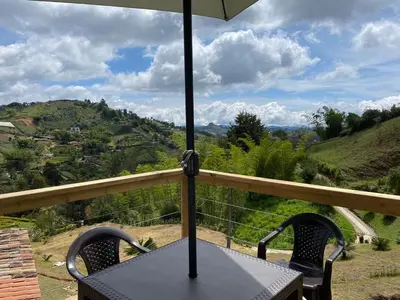 a table with an umbrella on top of a balcony at Hermosa Finca Con Piscina y Jacuzzi in El Peñol