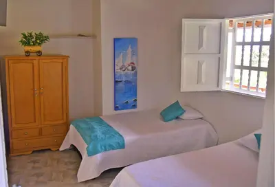 a bedroom with two beds and a cabinet and a window at Hermosa Finca Con Piscina y Jacuzzi in El Peñol