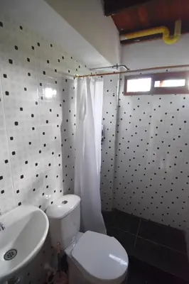 a bathroom with a white toilet and a sink at Cabaña cerca a hacienda Nápoles in Doradal