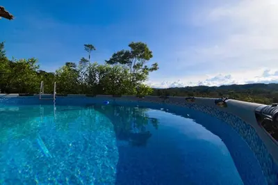 a large swimming pool with a view of the mountains at Cabaña cerca a hacienda Nápoles in Doradal