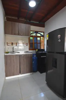 a kitchen with a sink and a refrigerator at Cabaña cerca a hacienda Nápoles in Doradal