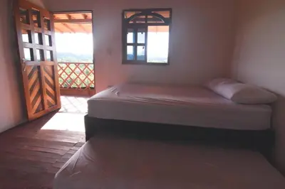 a bedroom with two beds in a room with a door at Cabaña cerca a hacienda Nápoles in Doradal