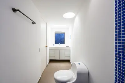 a white bathroom with a toilet and a window at 5BR Poblado Villa close to Lleras Jacuzzi Cinema AC in Medellín