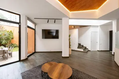 a living room with a table and a tv at 5BR Poblado Villa close to Lleras Jacuzzi Cinema AC in Medellín