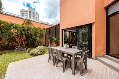 a wooden table and chairs on a patio at 5BR Poblado Villa close to Lleras Jacuzzi Cinema AC in Medellín