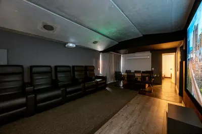 a room with leather chairs and a flat screen tv at 5BR Poblado Villa close to Lleras Jacuzzi Cinema AC in Medellín