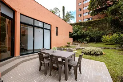 a wooden table and chairs on a patio at 5BR Poblado Villa close to Lleras Jacuzzi Cinema AC in Medellín