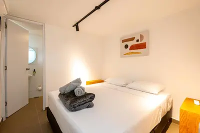 a bedroom with a white bed with towels on it at 5BR Poblado Villa close to Lleras Jacuzzi Cinema AC in Medellín
