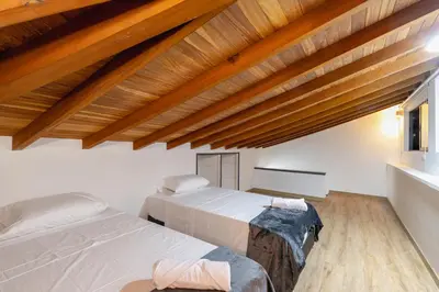 two beds in a room with wooden ceilings at B3 4BR Poblado Penthouse wit AC and Jacuzzi in Medellín