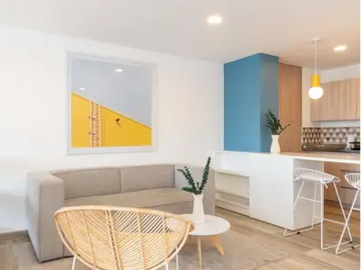 a living room with a couch and a kitchen at Modern Loft in Laureles in Medellín