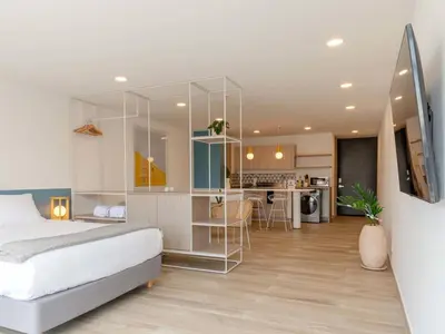 a bedroom with a bed and a kitchen at Modern Loft in Laureles in Medellín