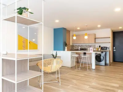 a kitchen and living room with a table and chairs at Modern Loft in Laureles in Medellín