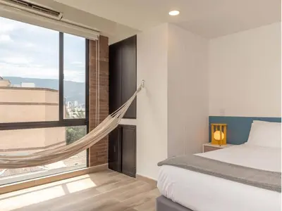 a bedroom with a hammock in front of a window at Modern Loft in Laureles in Medellín
