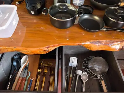 a wooden counter top with cooking utensils in a drawer at Espectacular Cabaña en Rionegro Antioquia, vista paisajes in Rionegro