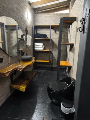 a bathroom with a black toilet and a sink at Espectacular Cabaña en Rionegro Antioquia, vista paisajes in Rionegro