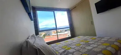 a bedroom with a bed and a large window at Mingle with the beautiful Paisas, Perfect location in Medellín