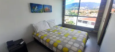 a bedroom with a bed and a large window at Mingle with the beautiful Paisas, Perfect location in Medellín