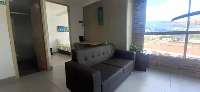 a living room with a couch and a bed and a window at Mingle with the beautiful Paisas, Perfect location in Medellín