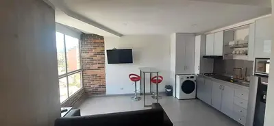a kitchen with white cabinets and a brick wall at Mingle with the beautiful Paisas, Perfect location in Medellín