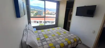 a bedroom with a bed and a large window at Mingle with the beautiful Paisas, Perfect location in Medellín