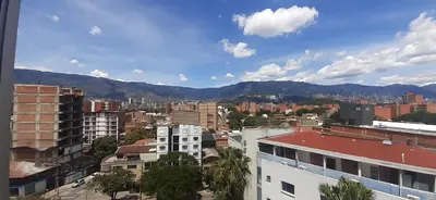 a city with buildings and mountains in the background at Mingle with the beautiful Paisas, Perfect location in Medellín