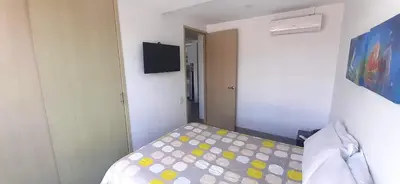 a small bedroom with a bed and a television at Mingle with the beautiful Paisas, Perfect location in Medellín
