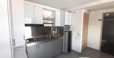 a kitchen with white cabinets and a stainless steel refrigerator at Mingle with the beautiful Paisas, Perfect location in Medellín