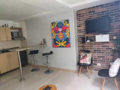 a living room with stools and a tv on a brick wall at Medellin- La 70, close to everything, Laureles retreat in Medellín