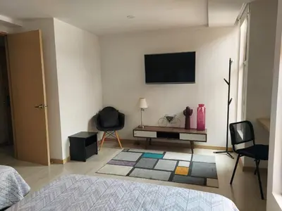 a bedroom with a bed and a tv on a wall at Medellin- La 70, close to everything, Laureles retreat in Medellín