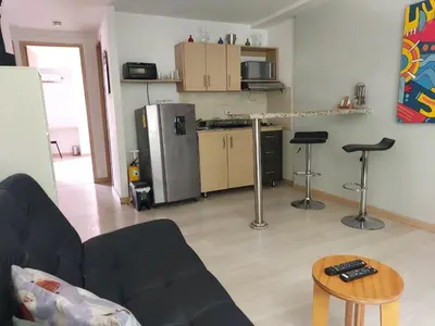 a living room with a couch and a kitchen at Medellin- La 70, close to everything, Laureles retreat in Medellín