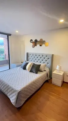 a bedroom with a large bed with a large window at Aparta estudio muy bien ubicado in Medellín